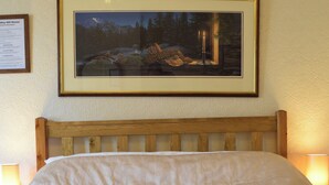 A neatly made bed with white linens and towels, a framed painting of a snowy landscape above it, and a wooden headboard. - Bewdley Hill House (Kidderminster)