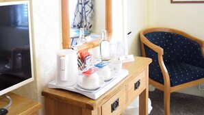 A hotel room with a wooden desk, a mirror, a framed picture on the wall, and a chair. - Bewdley Hill House (Kidderminster)
