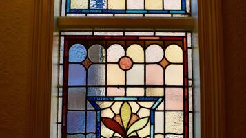 A stained glass window with floral patterns and geometric shapes.