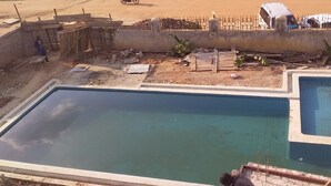 A swimming pool with a rectangular shape and a smaller adjacent pool. - Senevin Gardens Hotel (Kabwohe)