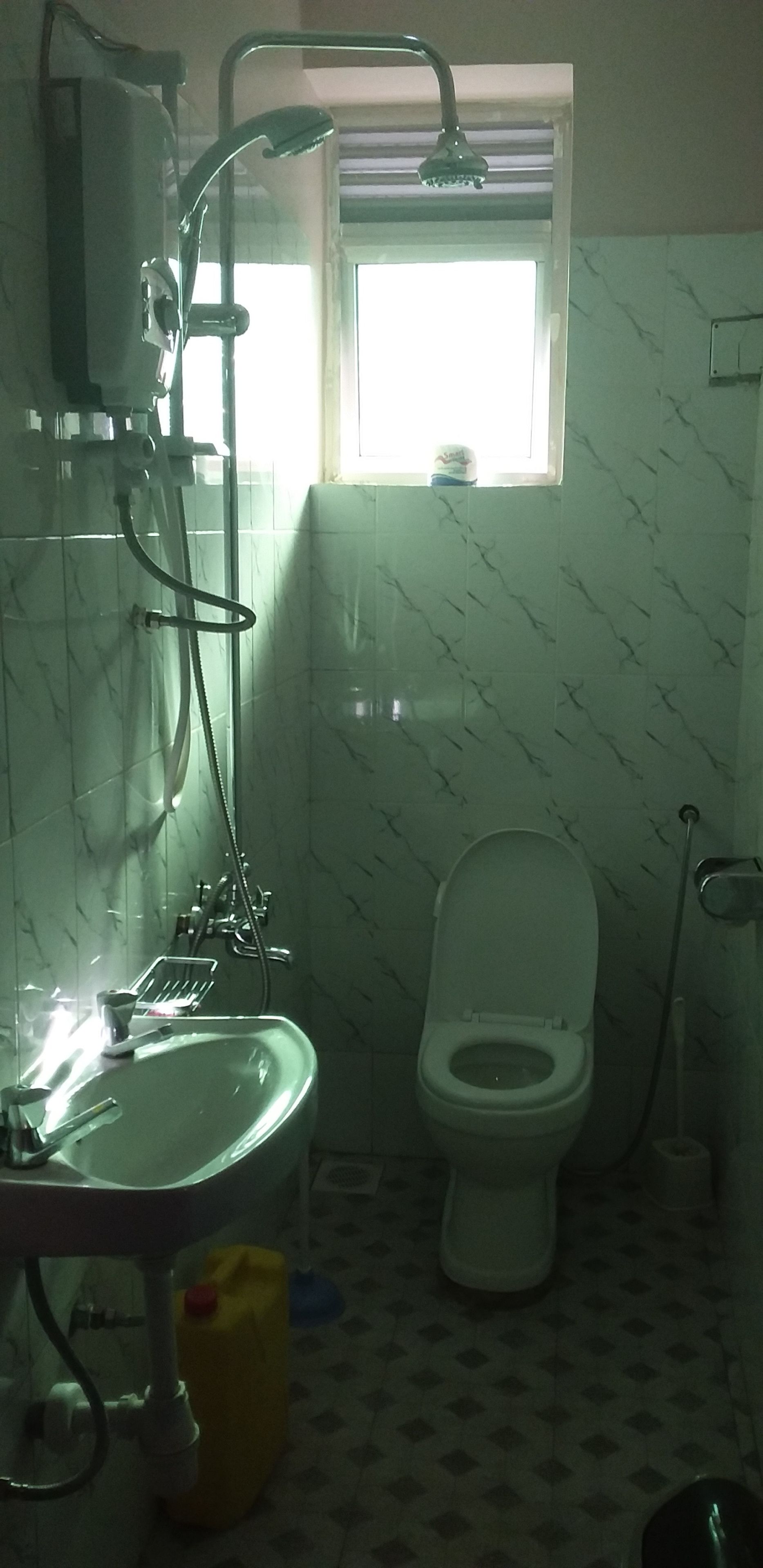A bathroom with a toilet, sink, and shower.