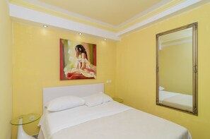 Ein Hotelzimmer mit Bett, einem Bild an der Wand und einem Spiegel.