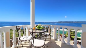 Balcón con mesa y sillas con vista al mar.