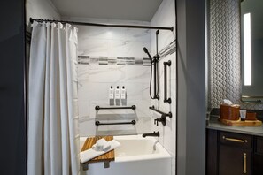 A modern bathroom with a bathtub, shower, and vanity.
