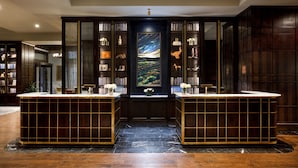 A library with two marble counters, bookshelves, and a large painting. - The Barfield, Autograph Collection (Amarillo)