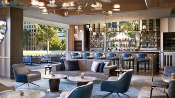 A modern bar area with seating, a bar counter, and a view of the outdoors.