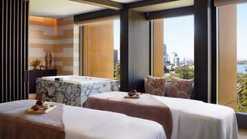 Enjoy breathtaking city views from this stylish room, featuring two beds, a bathtub, and a vanity.