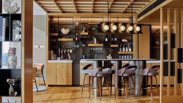 A modern kitchen with wooden cabinetry, a central island with bar stools, and a variety of kitchen appliances.