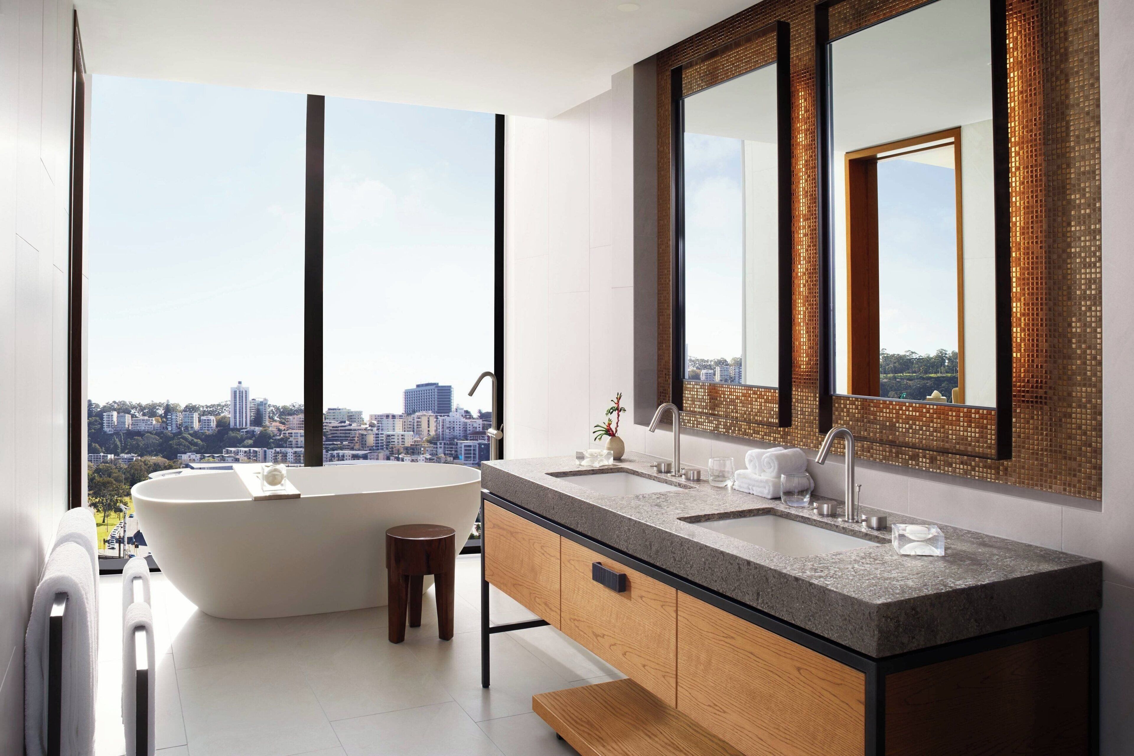 Un bagno moderno con una vasca freestanding, un lavabo doppio e ampi specchi.