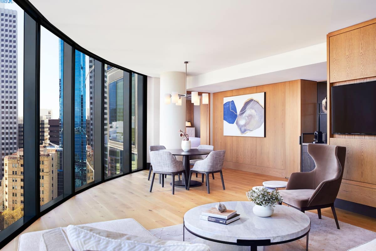 Una sala moderna con vista a la ciudad, un comedor y un televisor de pantalla plana.