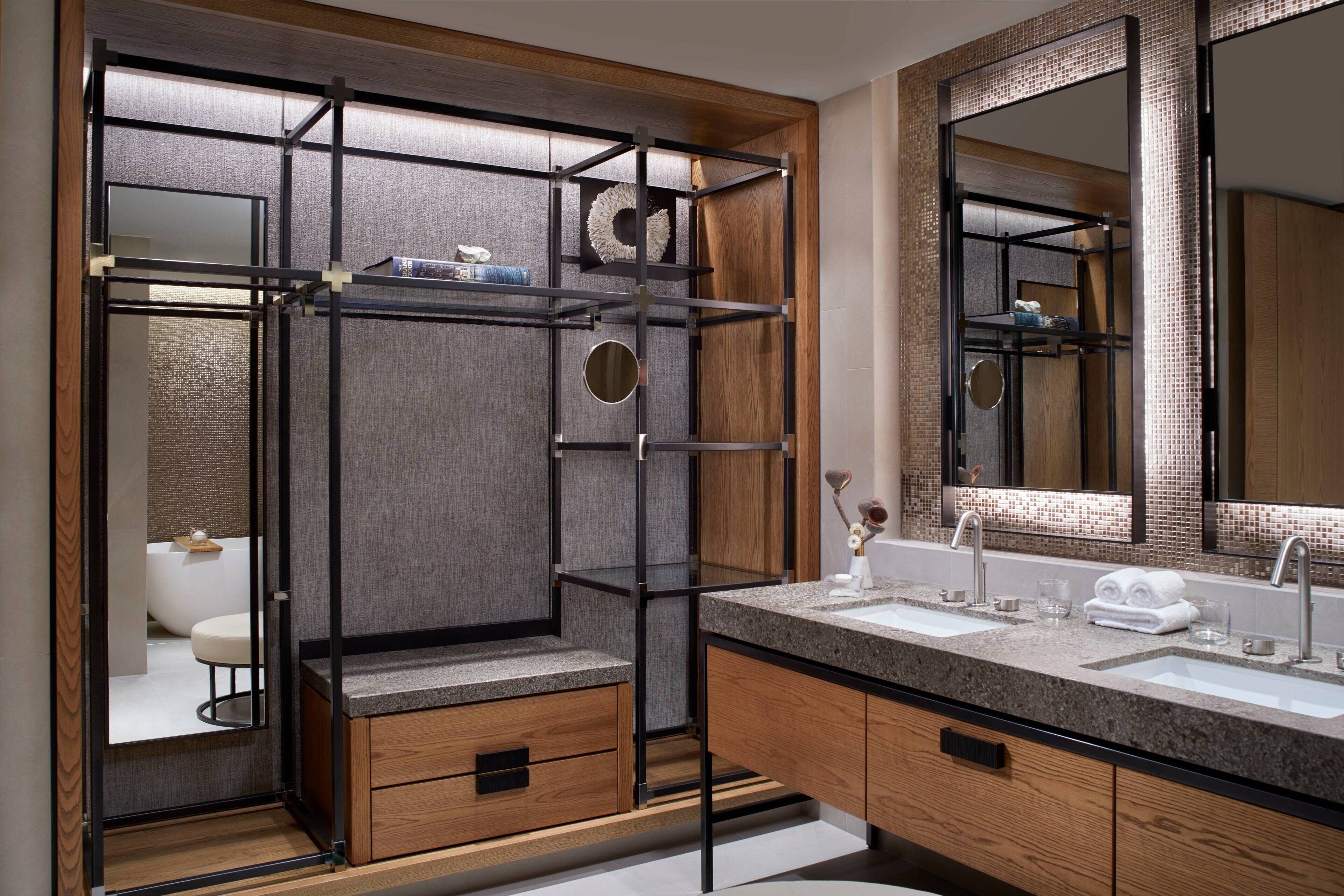 Un baño moderno con un espejo grande, dos lavamanos y un mueble de tocador de madera.