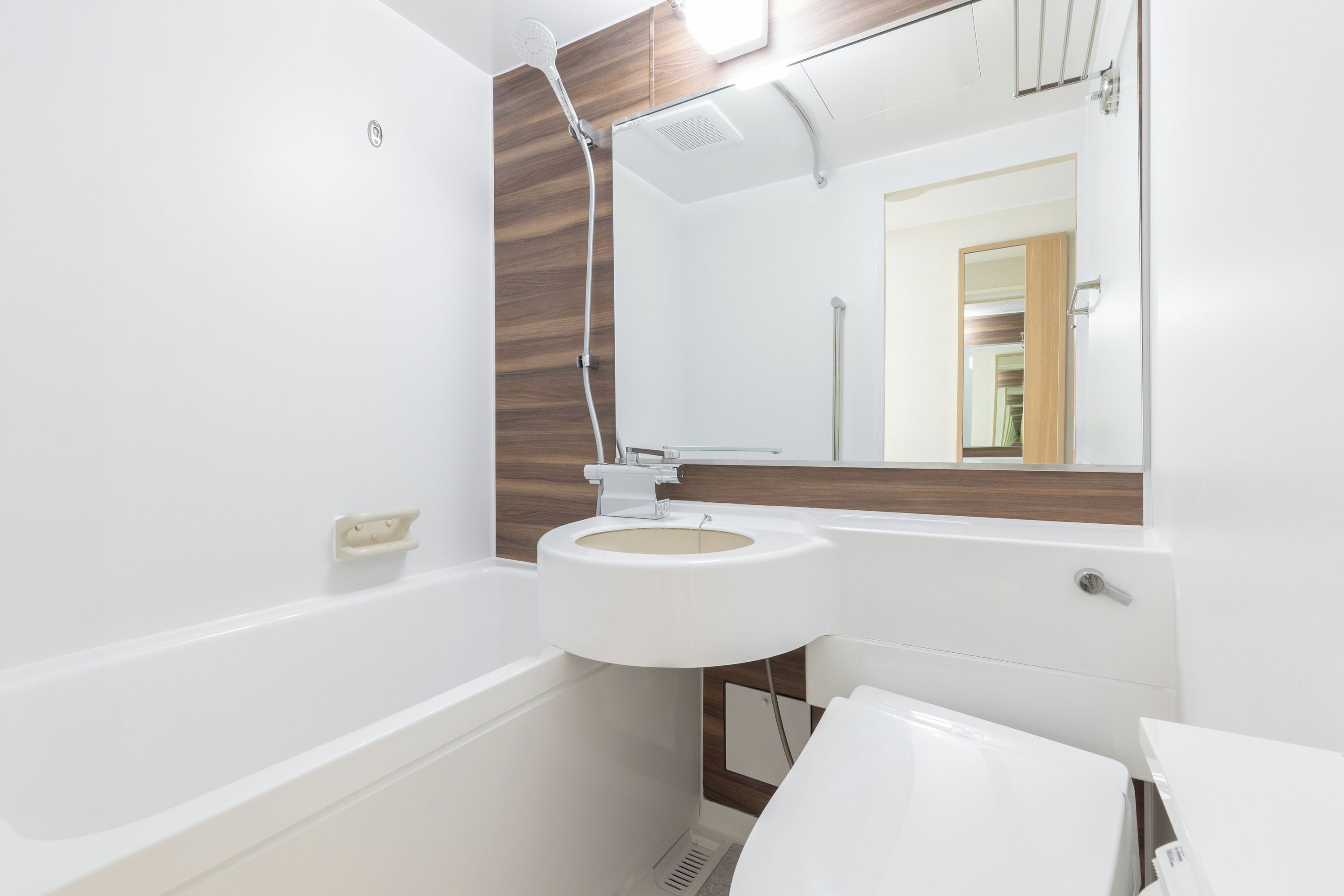 A modern bathroom with a bathtub, sink, and toilet.
