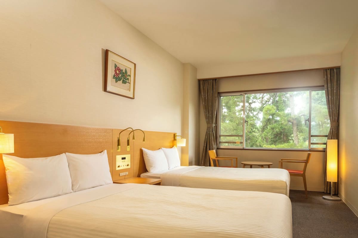 Una habitación de hotel con dos camas, un escritorio y una silla.