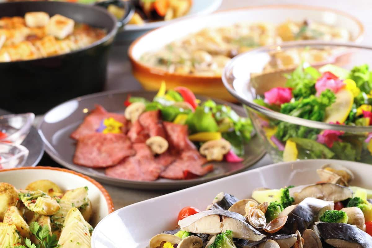 Una variedad de platos que incluyen mariscos, verduras y pasta.