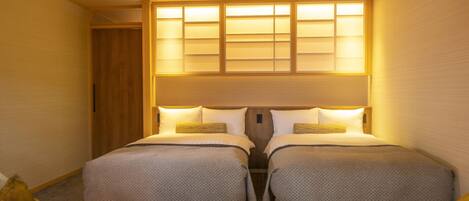 A hotel room with two beds, a small round table, and two chairs.