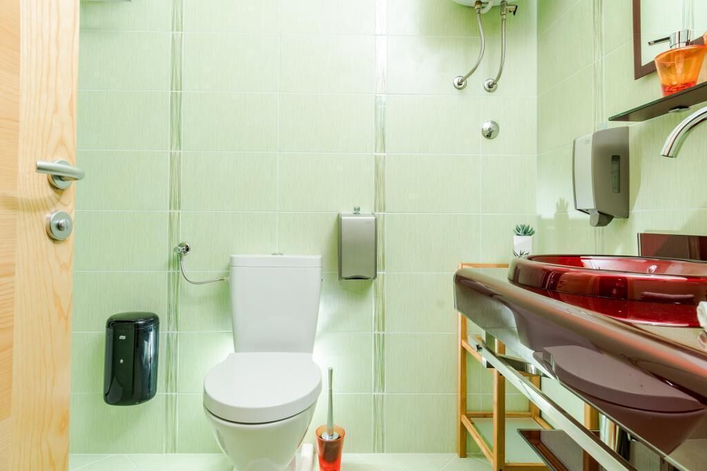 Ein Badezimmer mit Toilette, Waschbecken und Spiegel.
