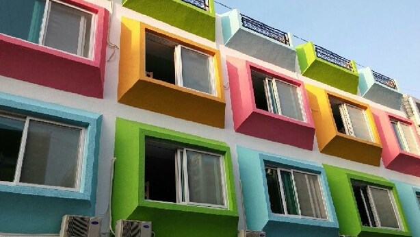 A multi-story building with colorful balconies and windows. - Jeonju Nangman Sidai Guesthouse - Hostel (Jeonju)