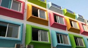 Un edificio de varios pisos con balcones y ventanas coloridas.