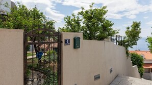Una entrada cerrada con un cartel que indica la habitación número 4, rodeada de vegetación y un cielo despejado.