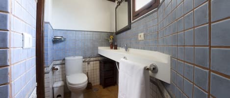 Un baño con inodoro, lavabo y espejo.