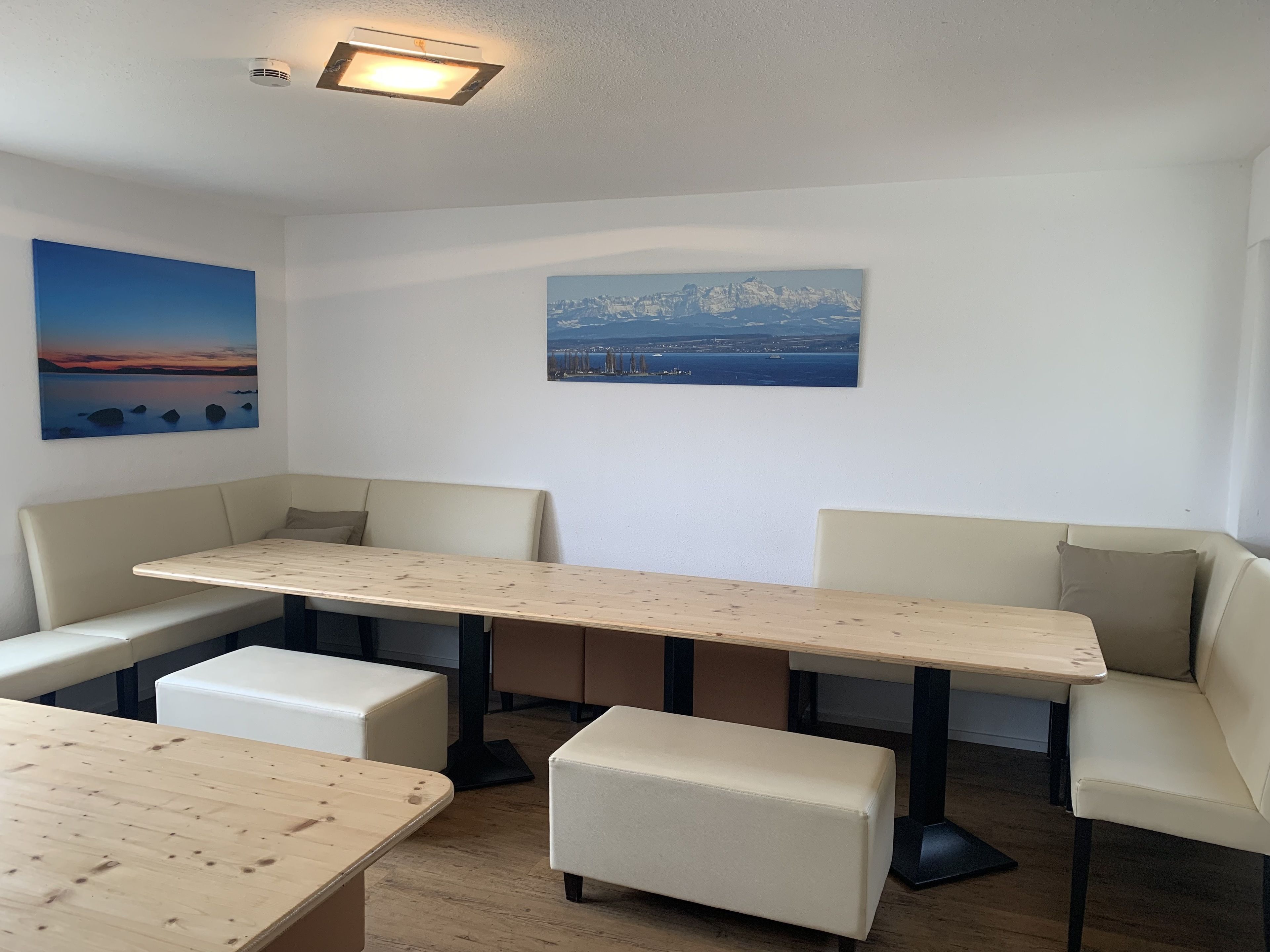 Un comedor moderno con una mesa de madera y asientos acolchados.