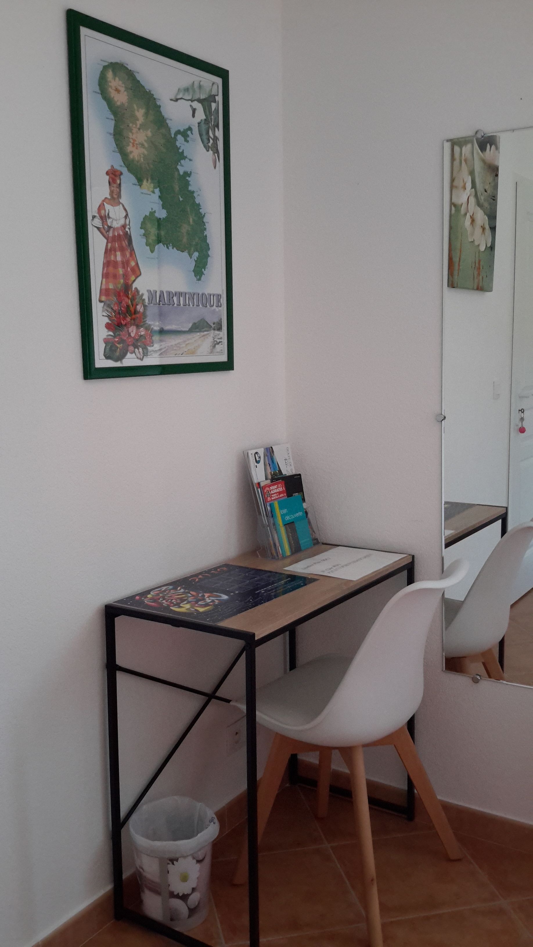 A small study area with a desk, chair, and a framed map on the wall.