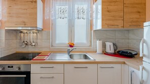 Een moderne keuken met een roestvrijstalen spoelbak, waterkoker, broodrooster en fornuis.