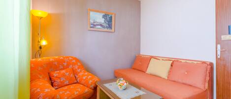 A small room with a sofa, a table, and a lamp.