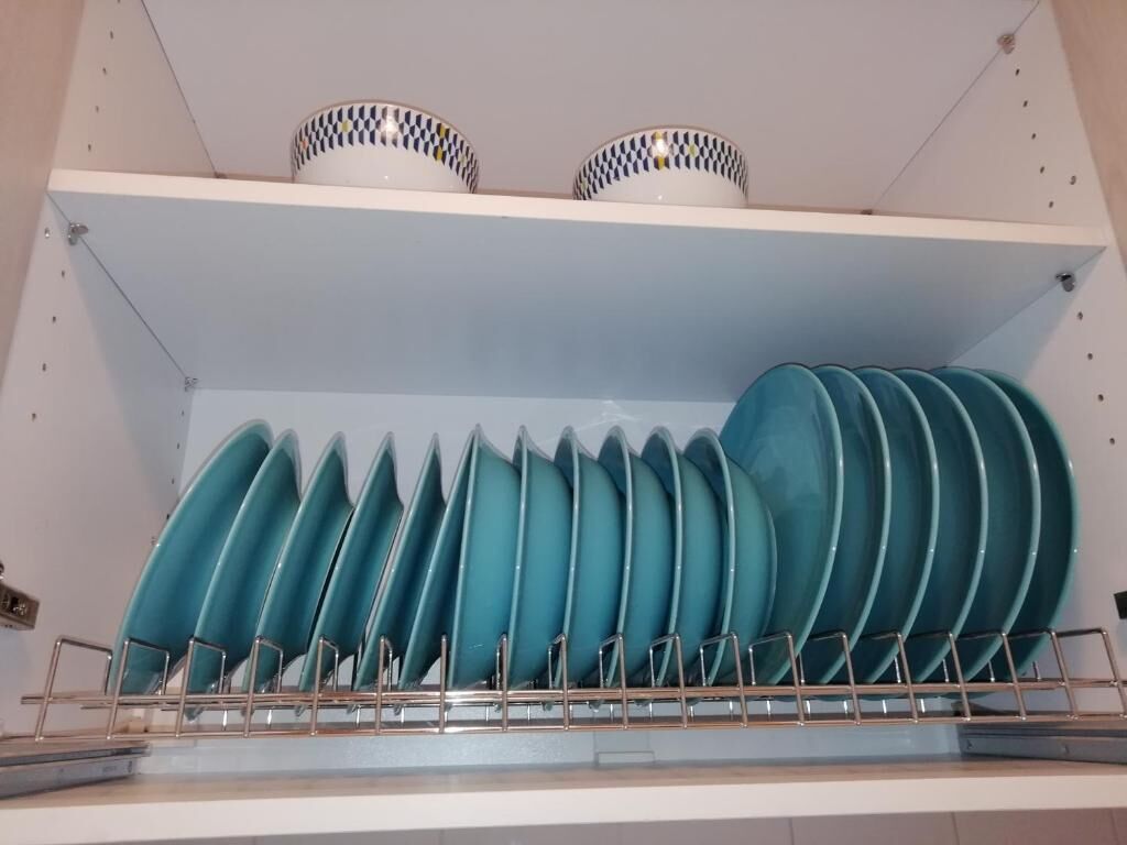A kitchen with a dish rack holding several plates and bowls.