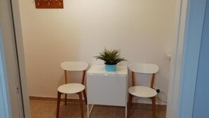 A small room with two white chairs, a white table, and a potted plant. - Margaritas house (Athens)