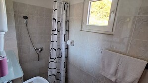 A bathroom with a shower, a sink, a toilet, a towel rack, and a window. - Apartments Dalmatin Žuljana - Studio Apartment 2 (Zuljana)