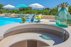 Relax by the serene pool surrounded by lounge chairs and lush greenery.