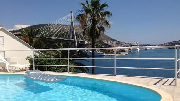 Una piscina con vistas a un puente y palmeras.
