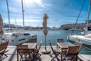 Relax on the deck with a view of the marina, surrounded by yachts and waterfront buildings.