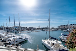 Stunning marina views with boats docked at the pier, surrounded by buildings and a distant Ferris wheel.