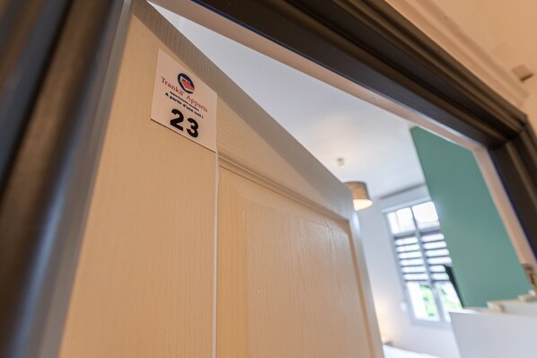 Puerta de una habitación de hotel con un letrero que indica el número 23.