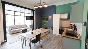 Une cuisine moderne avec un coin repas, un canapé et un téléviseur dans le salon.
