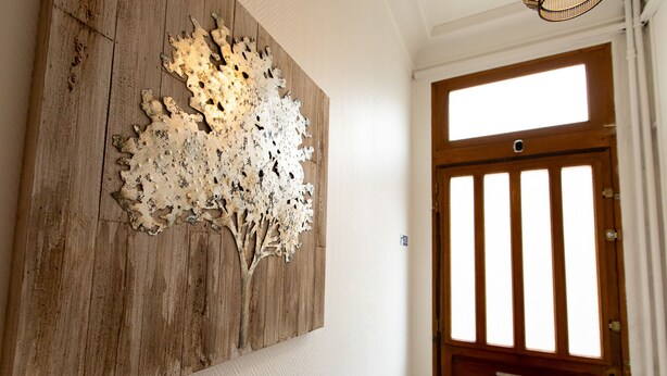 Un mur en bois orné d’une œuvre d’art abstraite à la texture particulière.