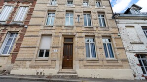 Un bâtiment historique doté d’une entrée centrale, de nombreuses fenêtres et d’une façade en briques.
