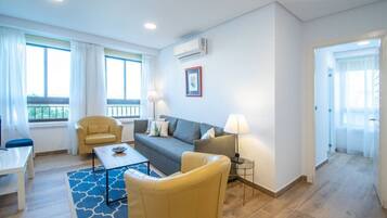 A modern living room with a sofa, armchairs, a coffee table, and a lamp.