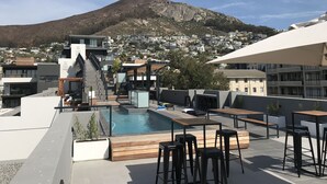 A rooftop pool area with a view of a mountain and a residential area in the background. - TenonQ C14 (Cape Town)