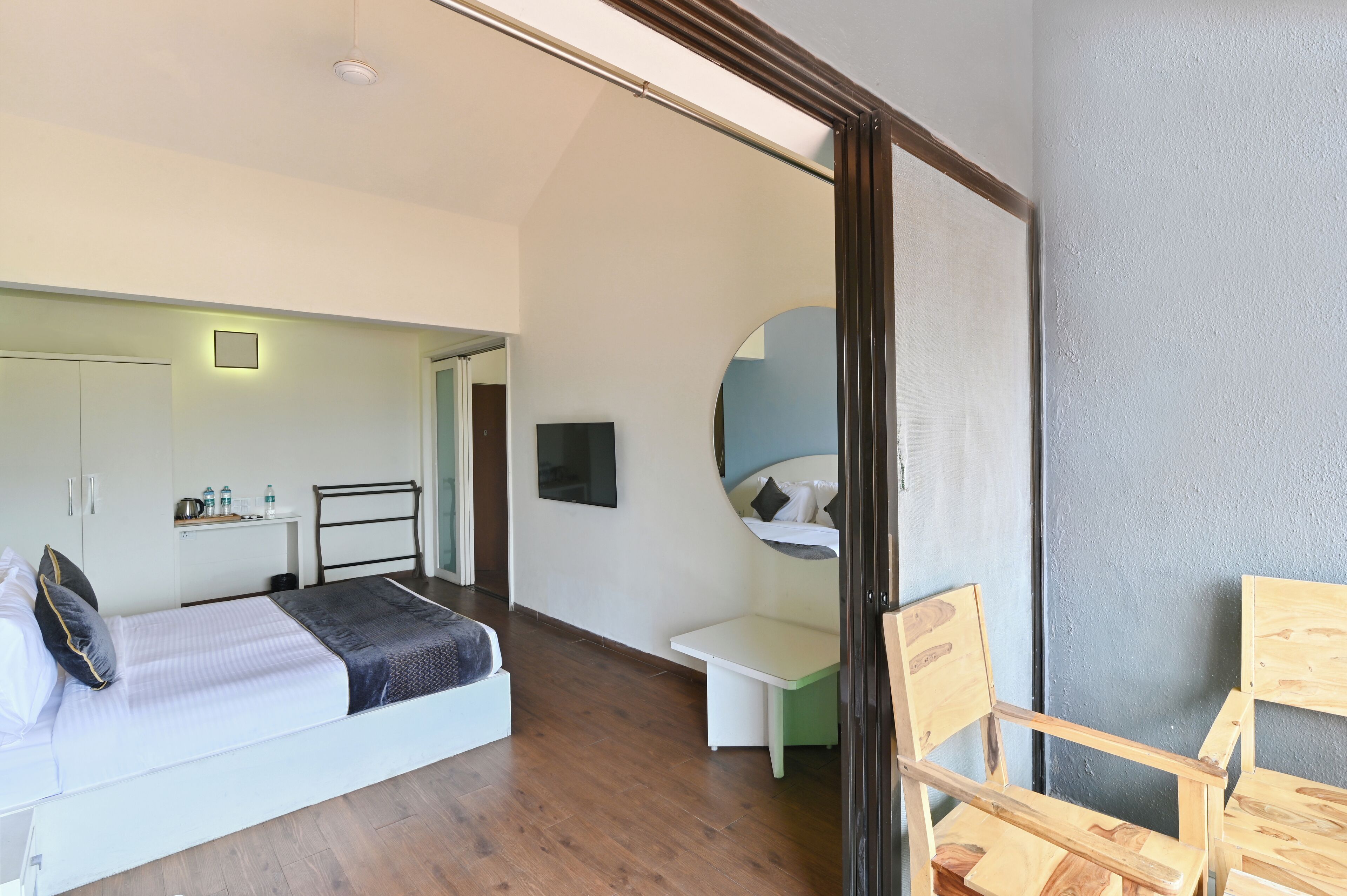 Un dormitorio moderno con cama, mesita de noche y espejo.