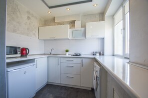 Enjoy cooking in this well-equipped kitchen with a stainless steel refrigerator, dishwasher, and ample natural light.