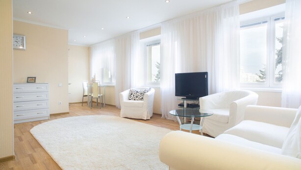 A modern living room with a flat-screen TV, a glass coffee table, and two white sofas. - iRent.by Nemiga (Minsk)