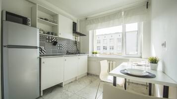 Business appartement | Privékeuken | Een koelkast met diepvriezer, een microgolfoven, een oven, een kookplaat