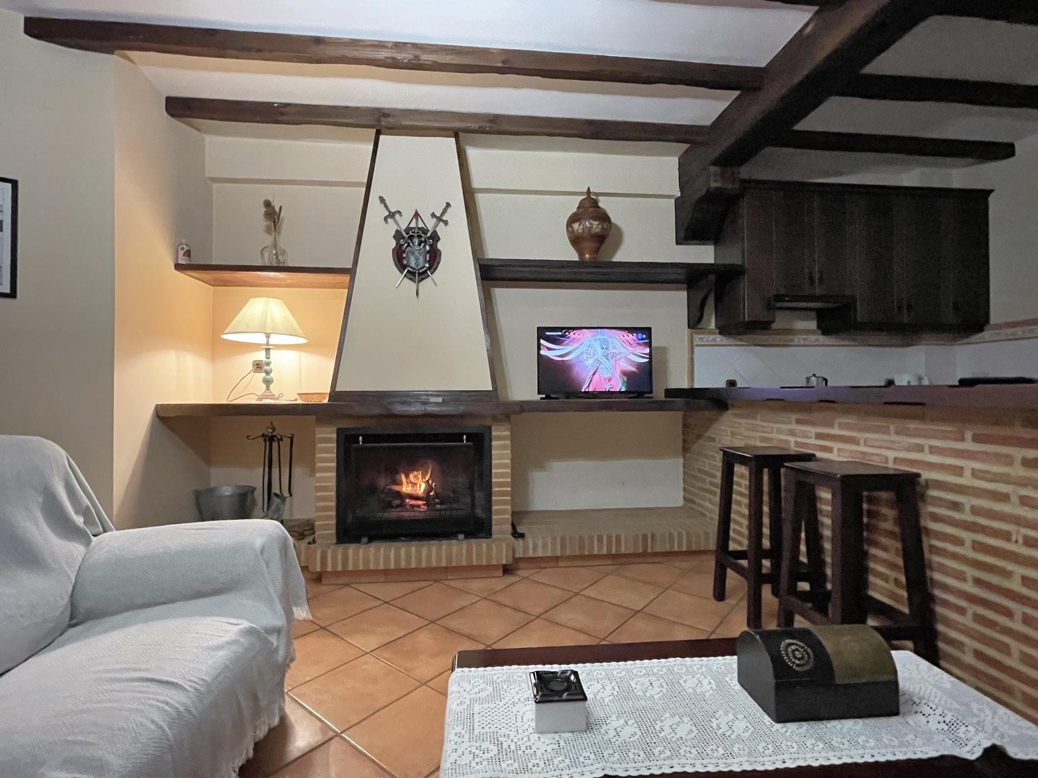 Una sala de estar acogedora con chimenea, televisor y un sofá cómodo.