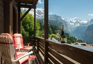 Eine Holzterrasse mit roten Sitzgelegenheiten und einer Flasche Moët & Chandon Champagner.
