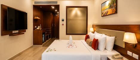 A hotel room with a bed, a television, a desk, and a painting on the wall.