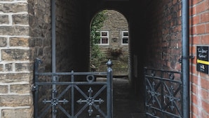 Una entrada de piedra arqueada a un edificio que dice 'The Old Mill'.