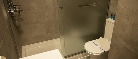 A bathroom with a shower, toilet, and sink.